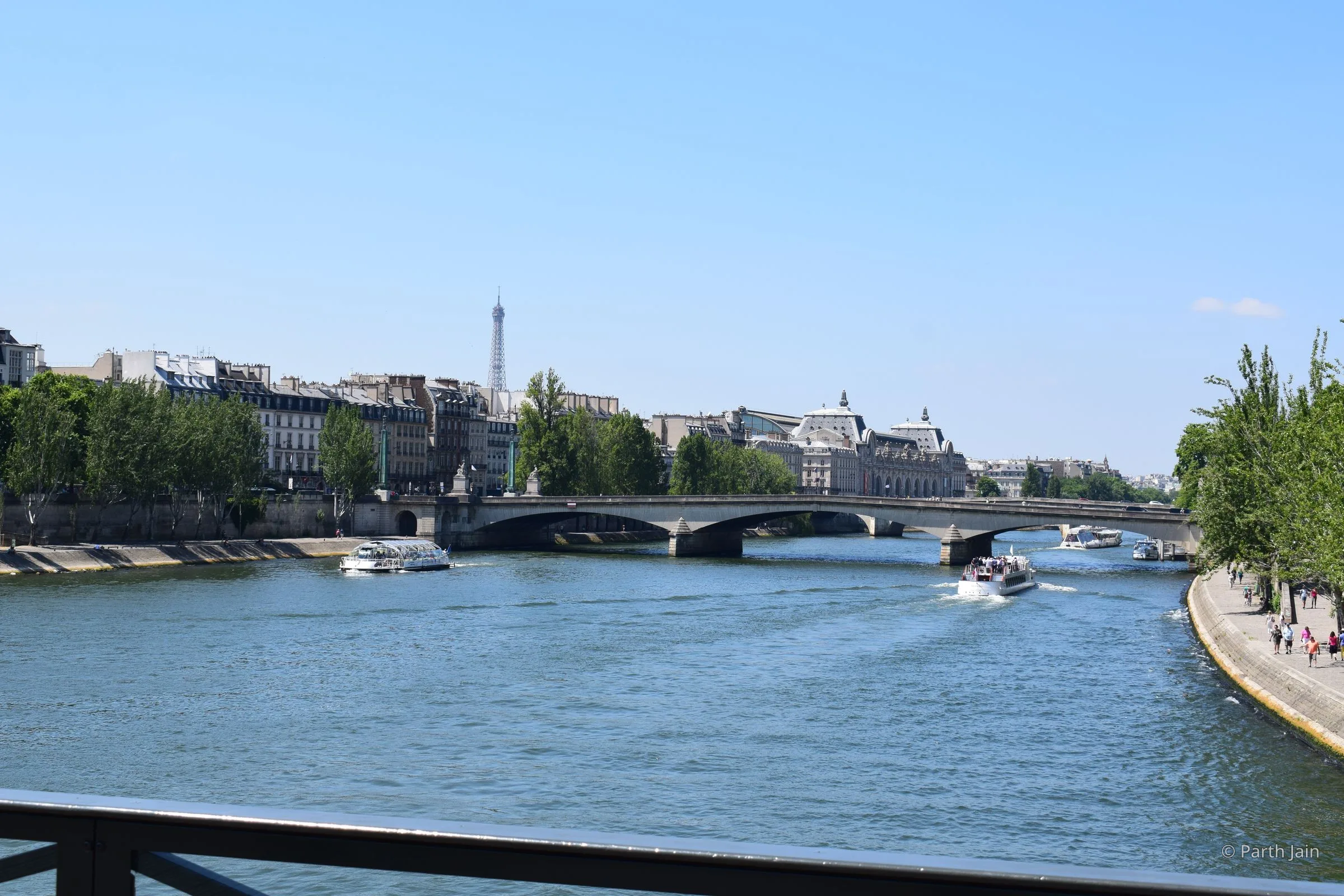 The Seine looking west from a footbridge, Eiffel Tower small on the horizon, Musée d'Orsay roof on the right.