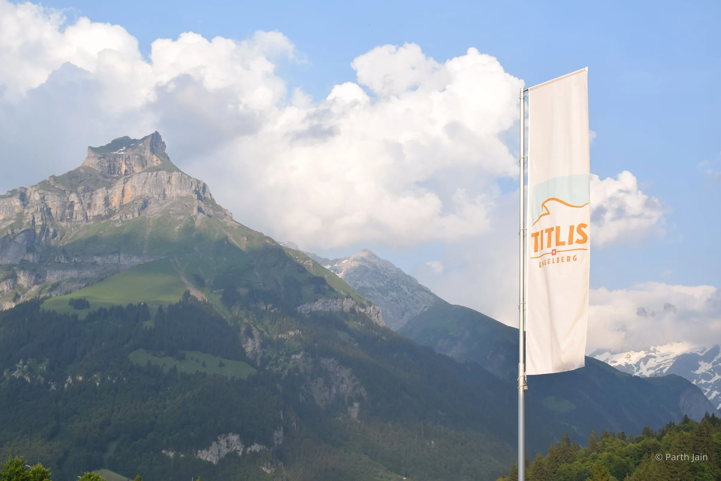A Swiss flag flying in Engelberg with Mt. Titlis in the background.